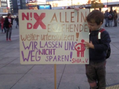 Foto von der Teilnahme an der Demo auf dem Alexanderplatz 2012, ein kleiner Junge hält das Plakat mit unseren SHIA-Forderungen