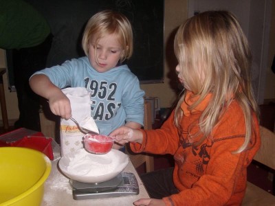 Foto von der Veranstaltung "Gemeinsam kochen", zwei kleine Mädchen sieben Mehl