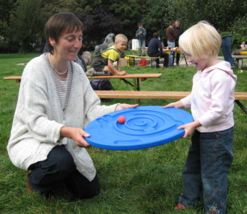 Foto von einer Frau mit Kind, die auf einer Wiese spielen